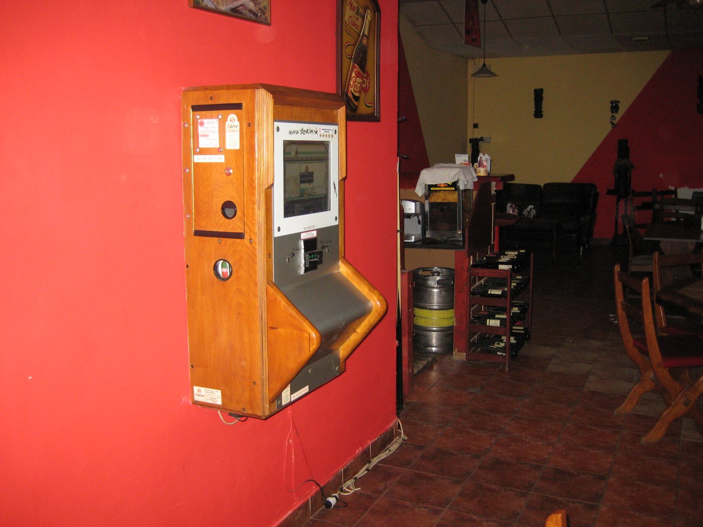 Drevený nástenný jukebox na červenej stene v interiéri prevádzky